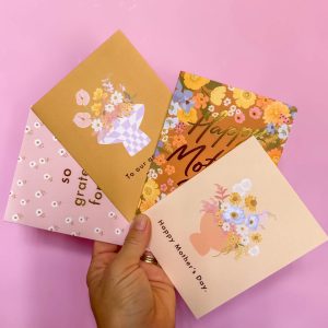 Four varieties of Mother's Day greeting cards held by a hand in a fan shape