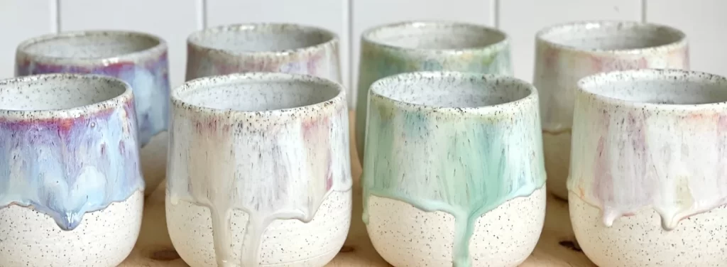 A collection of clay ceramic glazed latte cups in pastel tones of cream, blue, green and pink